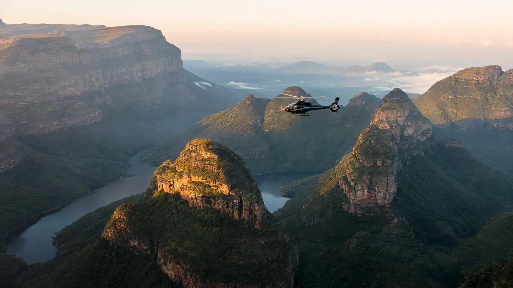 Private helicopter flying above the Three Rondavels and river gorge of the Blyde River Canyon