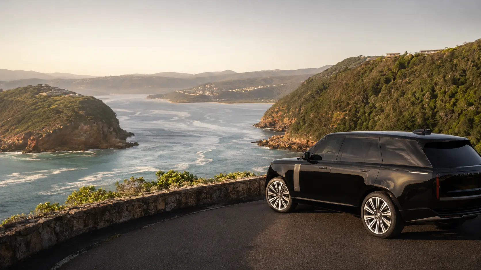 Black luxury SUV parked at a viewpoint above the Knysna Heads and lagoon on the Garden Route
